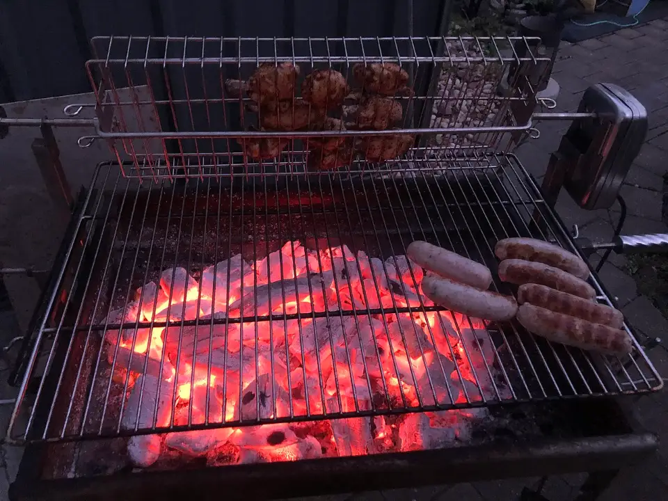 Brasas al rojo bajo la parrilla con carne
